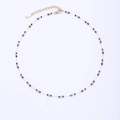 Detailed macro view of gold plated chain necklace with integrated black bead accents - Black Beads With Gold Spacers