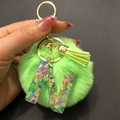 Detail of green faux fur pompom and resin letter W keychain with colorful sequins - Letter W