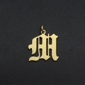 Close-up of Old English letter M pendant in gold plated stainless steel for DIY jewelry - M