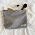 Minimalistische graue Kosmetiktasche aus Cord in der Draufsicht auf Textilhintergrund - Grau