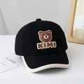 Détail d'une casquette bébé avec écusson ours et texte KIMI sur fond minimaliste - 50cm (1-3 ans) / Ours KIMI-Noir