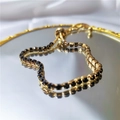 Bracelet doré ajustable avec cristaux carrés noirs sertis sur une surface réfléchissante - Noir