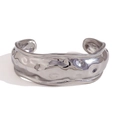 Brazalete plateado ajustable con textura orgánica de lava sobre un fondo blanco - Color Acero
