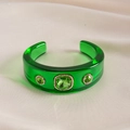 Close-up of green resin bangle featuring emerald-cut crystals and shimmering accents - Green