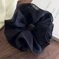 Chouchou géant noir élégant en tissu seersucker plissé sur fond de bois naturel - Chouchou en Tissu Plissé Noir
