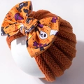 Detail van de oranje babygebreide muts met Halloween-pompoen- en spookstrikpatroondecoratie - Oranje