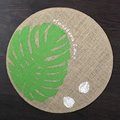 Round jute placemat featuring green monstera leaf print and white text on dark wood - 38cm / Green Monstera Leaf