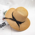Detailed weave texture of summer straw hat with black grosgrain ribbon bow decoration - Khaki