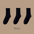 Three pairs of black cotton mid-calf socks with ribbed cuffs and smooth knit texture - Solid Slouch Socks (Black)