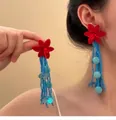 Dettaglio di orecchini a fiore rosso bohémien con lunghe nappe di perline blu - Orecchini a Nappa Con Perline Blu e Fiori Rossi