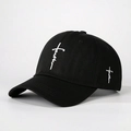 Close-up detail of white faith cross embroidery on black cotton baseball cap fabric - One Size / Black