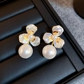 Primer plano detallado de pendientes de flores y perlas en bandeja de cuero negro premium - Cobre Chapado en Oro con Pin de Plata / Dorado