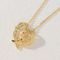 Detail of 18k gold heart pendant with crystal hand-in-hand motif on white texture - Gold Heart/Large Hand Holding Small Hand/Family Necklace