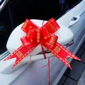 Red wedding bow with golden double happiness symbol on a white car side mirror - Trending Happiness Red