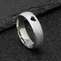 Macro detail of silver frosted stainless steel ring with a hollow heart-shaped cutout - US 6 / Steel Color Hollow Heart (6mm)