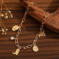 Detail of Western-style gold chain bracelet with cowboy hat and pearl charms on wood - Gold Western Pearl Necklace (26 KC Gold 5872)
