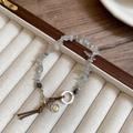 Primer plano detallado de las cuentas de piedra natural y el colgante de metal retro - Pulsera-Blanco