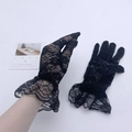 Close-up of black lace gloves with floral embroidery and elegant ruffled cuffs - Black Lace Gloves
