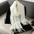 Close-up of white soft cashmere-like scarf texture with stylish fringe tassel edges - White