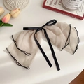 Elegant beige mesh hair claw clip with black ribbon bow and trim in a lifestyle setting - Silk Gauze Bow Spring Clip / Light Coffee