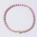 Handmade bohemian style beaded bracelet featuring purple beads and gold metal accents - Purple and Gold