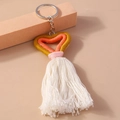 Gros plan d'un porte-clés coeur tricoté rose, orange et jaune avec pompons blancs - Jaune