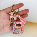 Detail of pink resin letter B keychain with butterfly charm and glitter sequins - Butterfly Tassel 8-Shape Buckle / Letter B