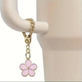 Detail of a pink flower charm with gold metal chain attached to a white tumbler handle - Pink