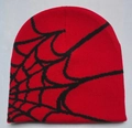 Close-up of red knitted beanie with black spider web jacquard pattern detail - Red with Black Web