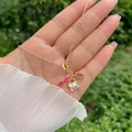 Dettaglio collana placcata oro 18K con ciondoli a forma di occhiali a cuore e borsa viola - Occhiali da Sole Busta Borsa 3 in 1