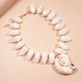 Resin beaded necklace featuring a large shell pendant and elegant gold spacer beads - White