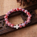 Detail of beaded bracelet with red, white and blue stones and a white cross charm - Vintage Red White Blue Cross Bracelet