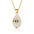 Macro detail of gold evil eye pendant with blue enamel and micro-pave cubic zirconia - White