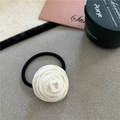 Close-up of a white velvet rose hair tie on a minimalist decorative stone surface - White