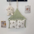 Nahaufnahme des karierten Wand-Organizers mit floralen Spitzentaschen und Holzaufhänger - Grünes Karo
