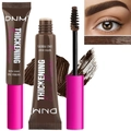 Detailed view of the fiber-enriched brow mascara tube, brush applicator and brown cream texture - Espresso