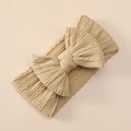 Macro shot of knitted beige nylon baby headband with textured jacquard bow detail - Tan