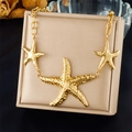 Close-up of gold starfish pendants on a chain inside a beige jewelry box - Triple Starfish Textured Style (N3506)