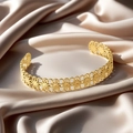 Elegant gold open bangle featuring intricate hollow flower textures on satin background - f39 Flower Hollow Style / Gold