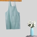 Cross-back light blue linen apron with large front pockets hanging on a wooden hook rack - Kids Light Blue