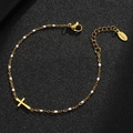 Detail of gold stainless steel cross bracelet with white beads and lobster clasp on black leather - Gold-White