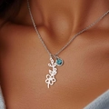 Collana con ciondolo a fiore argento e gemma blu indossata sul décolleté - Maggio