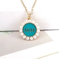 Detailed close-up of 11:11 lucky pendant with teal enamel and white faux pearls - Blue