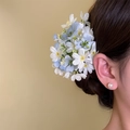 Gros plan d'une élégante pince à cheveux florale bleue et blanche portée par un modèle - Pince Crabe (51#) / 1 Pièce / Bleu
