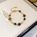 Detail eines Vintage-Perlenarmbands mit Tigerauge-Steinen und vergoldetem Verschluss - Gold-Braun (Vergoldet)