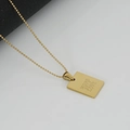 Macro detail of golden square military pendant with More Self Love engraving and bead chain - More Self Love