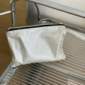 Nahaufnahme der silbernen Glitzer-Kosmetiktasche auf Glasregal mit Reißverschluss - Beige Glitzer