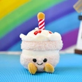 Close-up of a cute cake plush keychain with a smiling face and a striped candle - 12cm (Rainbow Rope) / Pink