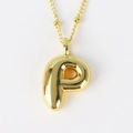 Macro shot of 3D bubble style letter P gold pendant necklace with minimalist beaded chain - Letter P
