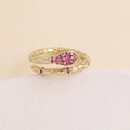 Detailed view of gold snake ring featuring vibrant pink micro-set cubic zirconia stones - Adjustable Open / Rose Red